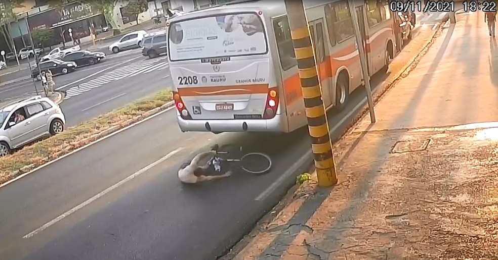 Ciclista sai ileso após deslizar e parar embaixo de ônibus
