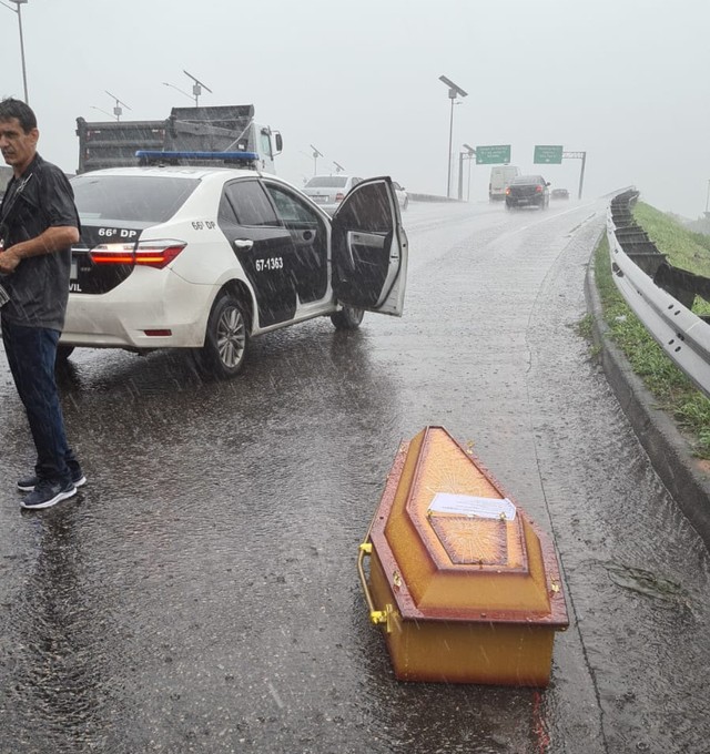 Caixão com corpo dentro cai em rodovia durante chuva no RJ