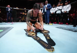 Amanda Nunes deixou os cinturões e suas luvas no centro do octógono — Foto: Jeff Bottari/Getty Images