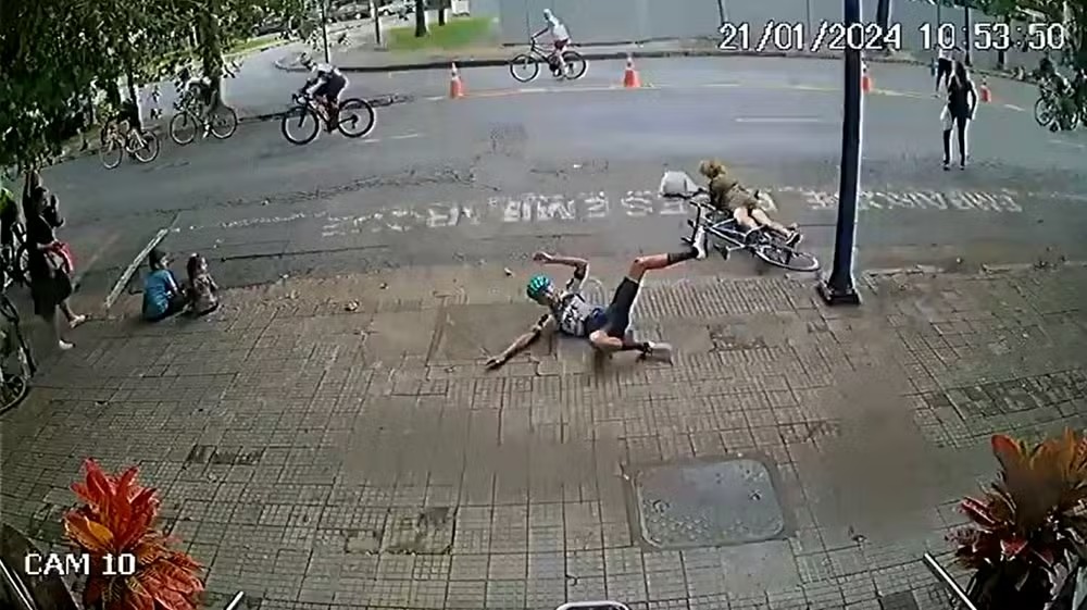 Idosa é atropelada por competidor ao atravessar rua durante prova ciclística. Câmera de segurança flagrou o acidente em Poços de Caldas (MG).